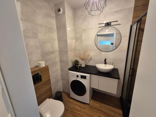 un bagno con lavandino, WC e specchio di Apartament Słoneczny Taras przy Aquapark Reda a Rumia