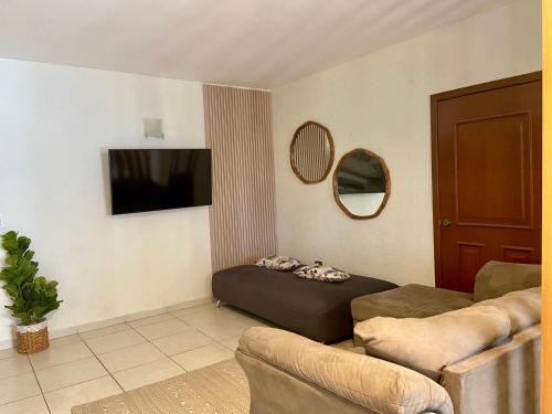 a living room with a couch and a flat screen tv at Hermoso condominio frente al mar in San Carlos