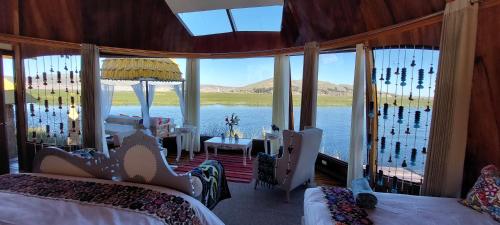 a bedroom with two beds and a view of the water at Uros Lodge Perú in Puno