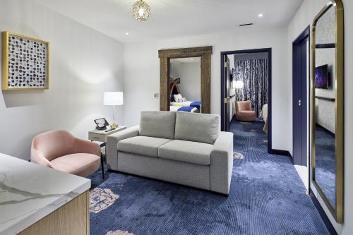 a living room with a couch and a chair at Universal Helios Grand Hotel, a Loews Hotel in Orlando