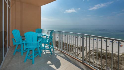 a balcony with blue chairs and the ocean at Phoenix Gulf Towers 806 condo in Gulf Shores