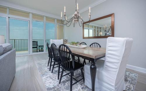 a dining room with a table with chairs and a mirror at Phoenix Gulf Towers 806 condo in Gulf Shores