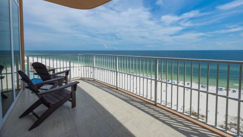 a balcony with two chairs looking out at the beach at Phoenix Gulf Towers 1008 condo in Gulf Shores