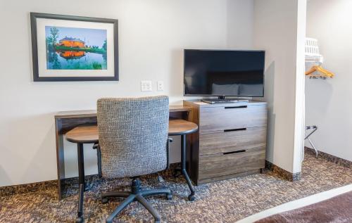 a room with a desk and a tv and a table and chairs at My Place Hotel-Grand Rapids, MN in Grand Rapids