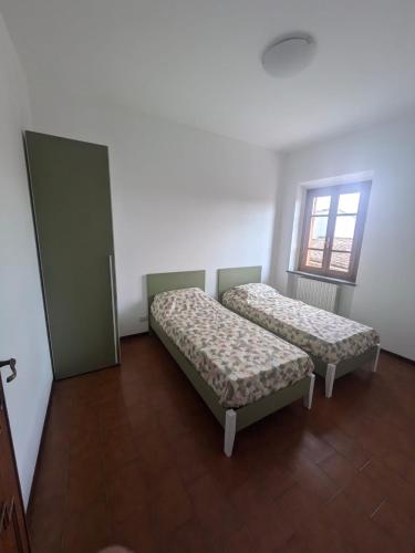 una stanza con due letti e una finestra di Appartamento Rimortoli a Lucca