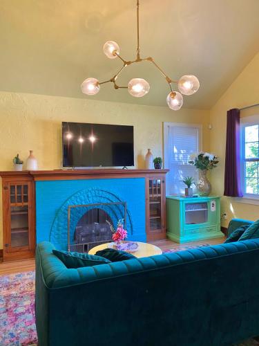 a living room with a blue couch and a fireplace at Pastel Palace - near Plaza & Uptown 23rd in Oklahoma City