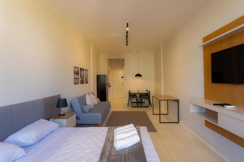 una camera da letto con un letto, un divano e una televisione di 360 Centro Metrô Uruguaiana By SUHCasa a Rio de Janeiro