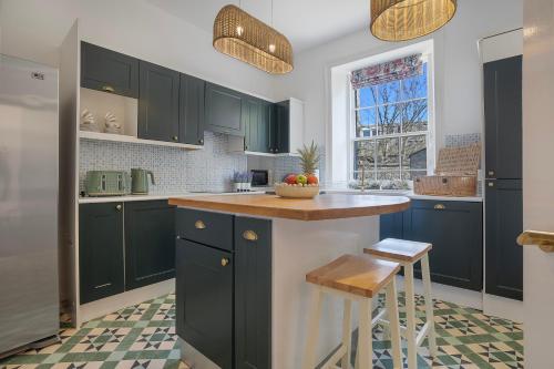 a kitchen with green cabinets and a counter top at Silver Street Townhouse - Grampian Lettings in Aberdeen