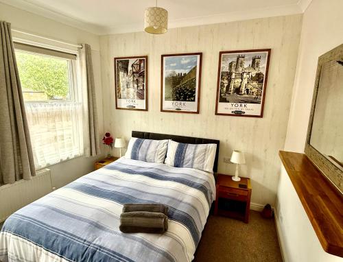 Un dormitorio con una cama y cuadros en la pared. en Cosy Victorian Apartment - Central York, en York