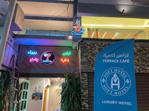 a sign on the side of a building with neon signs at Soft Hotel in Cairo