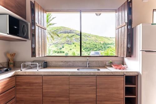 a kitchen with a sink and a window at Bonito Aconchegante no Hotel Pedra do Rodeadouro Bonito PE in Bonito
