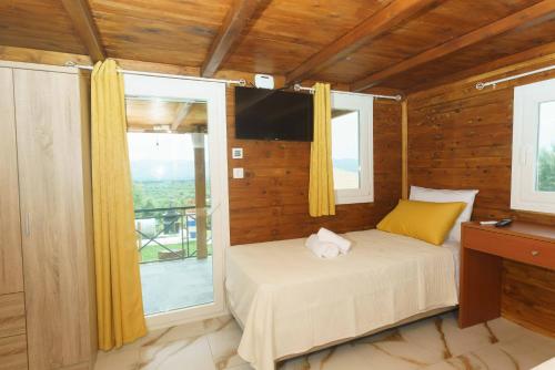 a bedroom with a bed and a large window at Bellus Residence 2! in Ambeloúzos