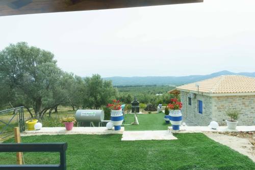 a yard with potted plants in front of a house at Bellus Residence 2! in Ambeloúzos
