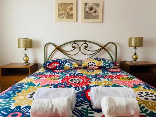 a bedroom with a colorful bed with towels on it at SwordFish City Center Apartment in Peniche