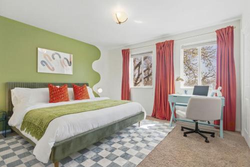 a bedroom with a bed and a desk with a laptop at Spacious 4BD - Backyard BBQ, Fire Pit & Mini Golf in Arvada