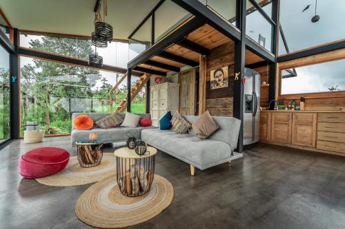 a living room with two couches and a kitchen at Chocó 701 La Reserva- Casa Murillo in Nanegalito