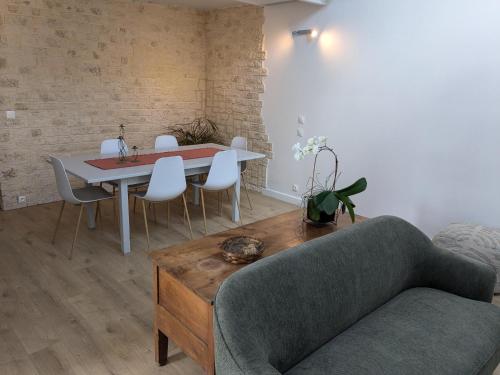 un salon avec une table et des chaises blanches dans l'établissement Les pins du teich, au Teich