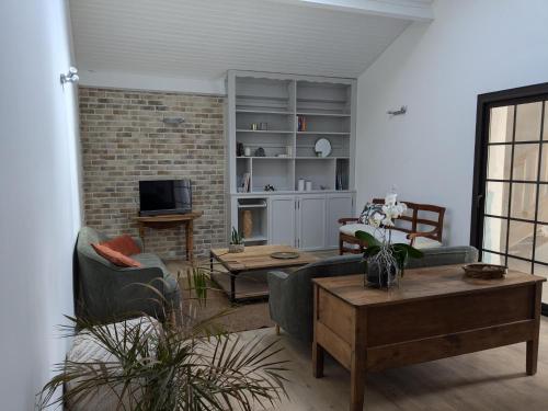 un salon avec deux canapés et une télévision dans l'établissement Les pins du teich, au Teich