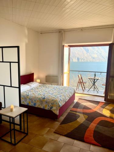 a bedroom with a bed and a view of the ocean at Appartamento sul Lago con Terrazza Panoramica in Riva di Solto