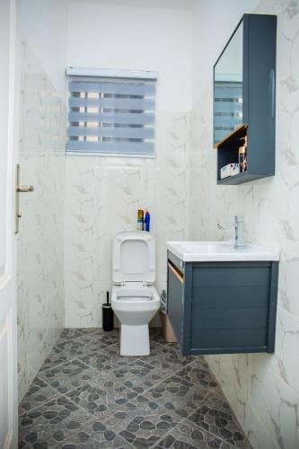 a bathroom with a toilet and a sink at No4 Wisdom Court in Accra