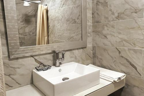 een badkamer met een witte wastafel en een spiegel bij Centrico loft6 en Pto Vallarta in Puerto Vallarta