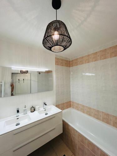 une salle de bain avec un lavabo, une baignoire et un miroir dans l'établissement Le Nicol's-PISCINE-PARKING-WIFi, à Béziers