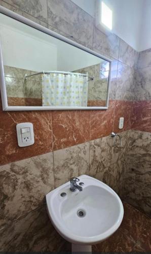 a bathroom with a sink and a mirror at Departamento Pellegrini in San Pedro