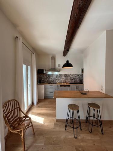 une cuisine avec un comptoir et des tabourets dans une pièce dans l'établissement Appartement 2 chambres-Vue imprenable sur la Cathédrale-Wifi, à Béziers