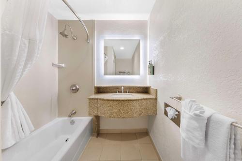a bathroom with a sink and a tub and a mirror at Best Western Plus Ontario Airport & Convention Center in Ontario