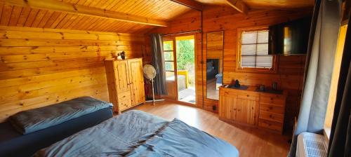 una camera con 2 letti in una baita di tronchi di Ferienhaus Im Wäldchen in See Nähe a Templin
