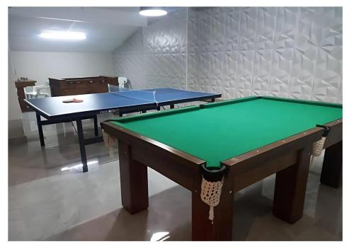 two ping pong tables in a room at Apto Aconchegante Piscina 2 Vagas in Guarujá