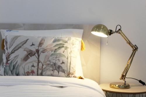 ein Schlafzimmer mit einem Bett mit Kissen und Lampe in der Unterkunft Valbom Hideaway Light, Style and Peace in Valbom