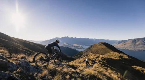 a person riding a bike on a hill at Tranquil Luxury on Willow Pond in Queenstown