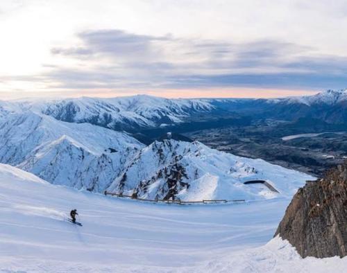 a person is skiing down a snow covered mountain at Tranquil Luxury on Willow Pond in Queenstown