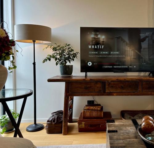 a living room with a tv on a wooden table at Tranquil Luxury on Willow Pond in Queenstown