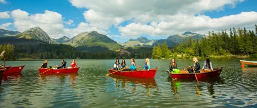 a group of people in red boats on a lake at Hotel AquaCity Mountain View in Poprad