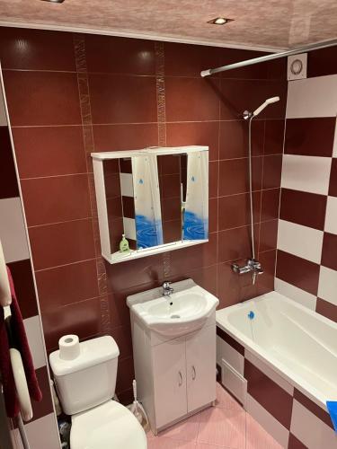 a bathroom with a toilet and a sink and a tub at KRL&Lu Rentals in Panevėžys