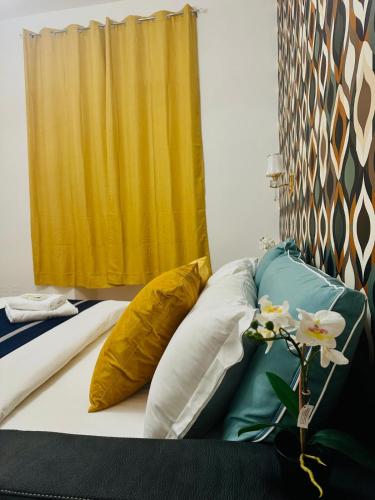a bedroom with a bed with pillows and a yellow curtain at Rome Termini Down-town Accommodation in Rome