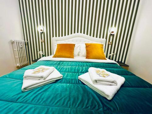 a bedroom with a blue bed with towels on it at Rome Termini Down-town Accommodation in Rome