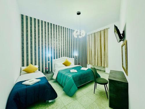 a hotel room with two beds and a chair at Rome Termini Down-town Accommodation in Rome