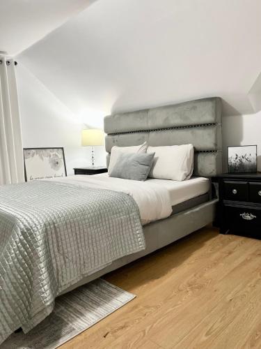 a bedroom with a large bed with a gray headboard at Charming beautiful house 7mn to downtown Ottawa in Gatineau