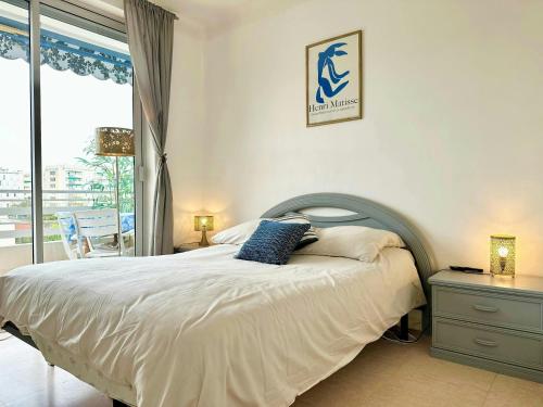 une chambre avec un grand lit et une fenêtre dans l'établissement Nice 1 bedroom, sea view, 10 min from Cannes Center & Palais des Festivals, à Cannes
