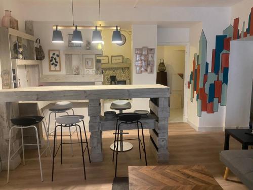 - une cuisine avec un bar avec des tabourets dans l'établissement Cosy et Charmant Appart 80 m2 au Panier - Vieux Port, à Marseille