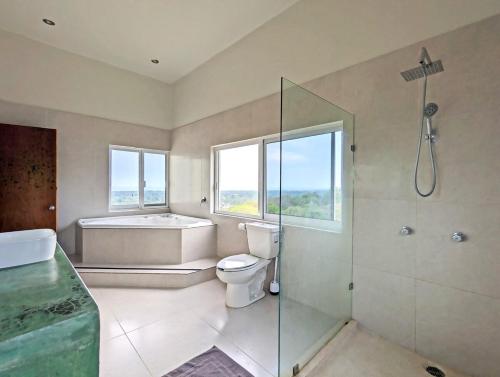 a bathroom with a tub and a toilet and a shower at Epic Views - 7 min from airport in Bajos de Chila