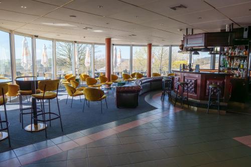 a lobby with chairs and a bar with a view at L'Hôtel et Restaurant du Golf de Clervaux in Eselborn