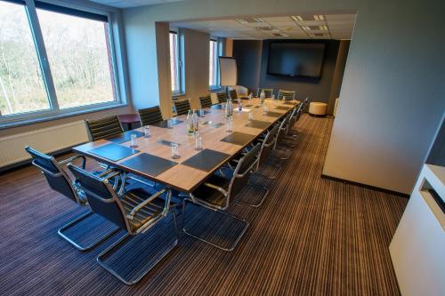 a large conference room with a long table and chairs at L'Hôtel et Restaurant du Golf de Clervaux in Eselborn