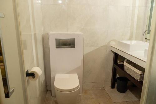 a white bathroom with a toilet and a sink at Almond Tree Villa Beach Hideaway with Jacuzzi in Gros Islet
