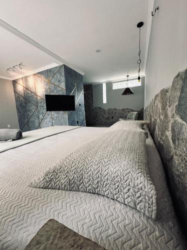 a bedroom with a large bed with a tv on the wall at Villa Suíça Guaramiranga in Guaramiranga