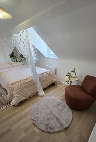 une chambre avec un lit et une chaise dans l'établissement L'alcôve enchantée, à Rouen