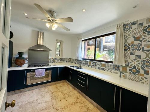 eine Küche mit schwarzen Schränken und einem Deckenventilator in der Unterkunft Villa Arqueologica in Playa del Carmen